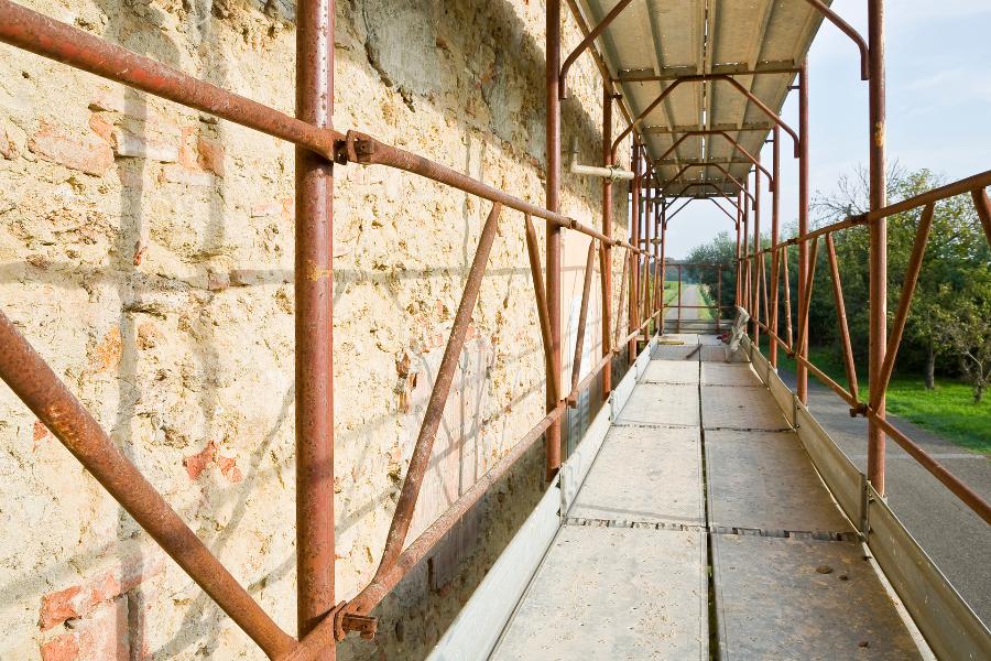 Lavori di costruzione in un cantiere edile con impalcatura metallica di sicurezza