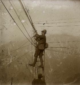 Fotografo: Autore non identificato Prima Guerra Mondiale: soldato su una scala mentre aggiusta cavi elettrici 1914-1918 Archivi Alinari, Firenze