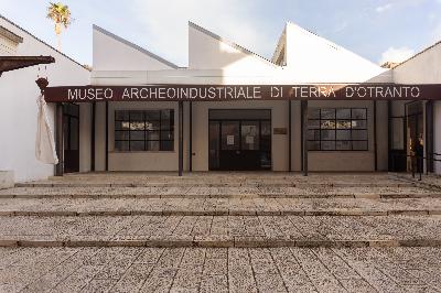Ingresso del Museo Archeoindustriale di Terra d’Otranto, con facciata bianca e insegna scura.