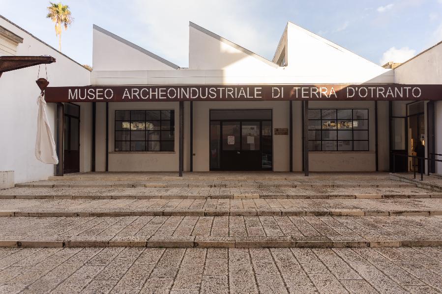 Ingresso del Museo Archeoindustriale di Terra d’Otranto, con facciata bianca e insegna scura.