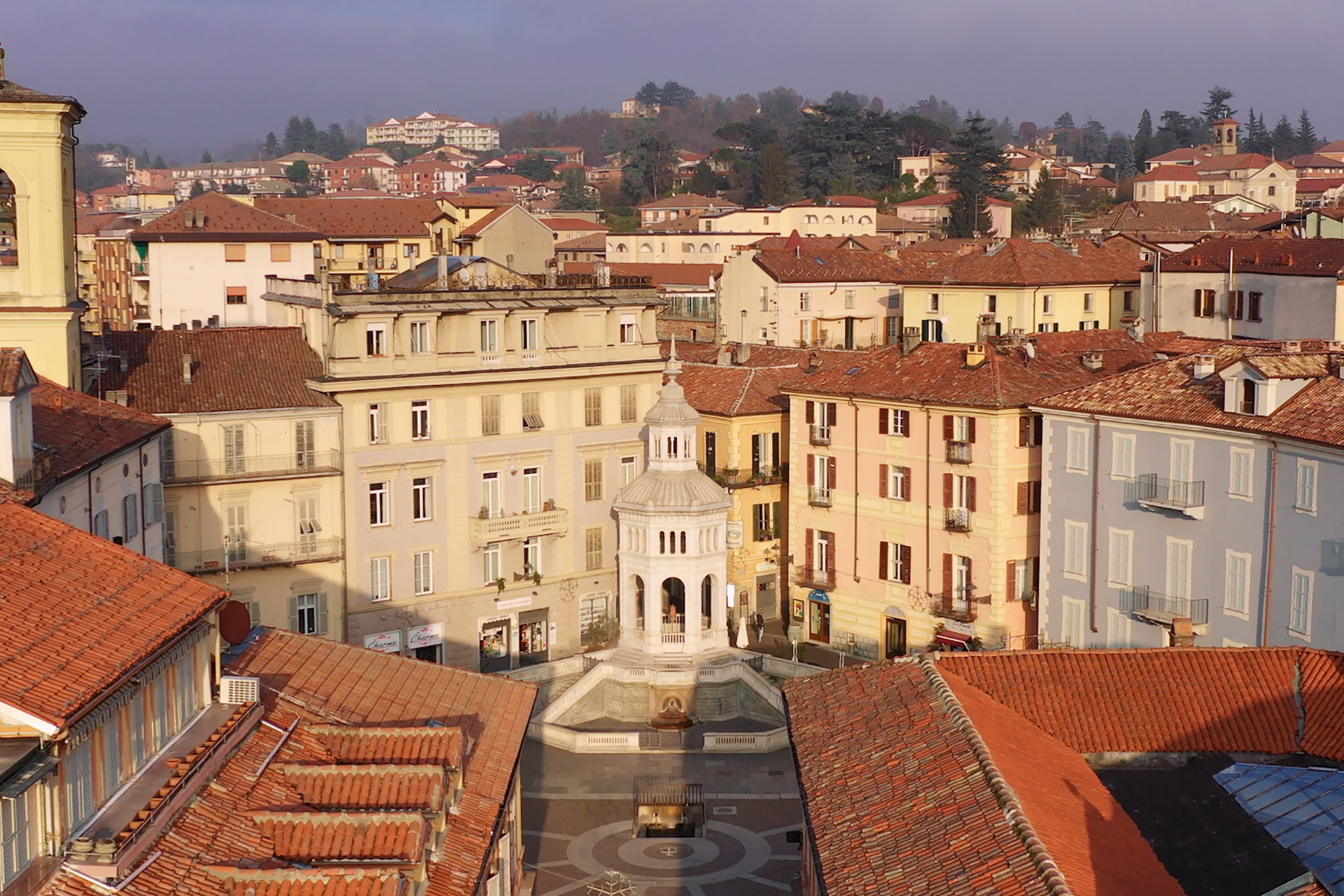 Veduta aerea del centro storico di Acqui Terme con palazzi e tetti rossi.