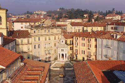 Veduta aerea del centro storico di Acqui Terme con palazzi e tetti rossi.