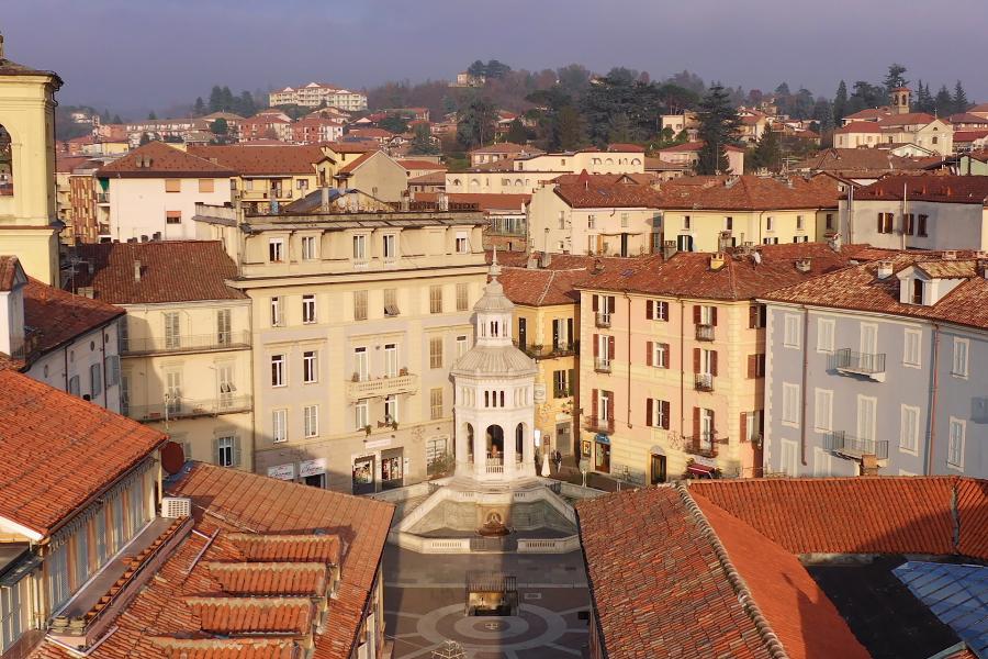 Veduta aerea del centro storico di Acqui Terme con palazzi e tetti rossi.