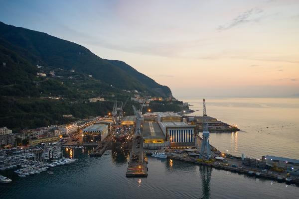 Industrial harbor with a cargo ship, cranes, and skyscrapers in the background