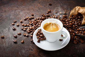 Tazzina di caffè con chicchi tostati.