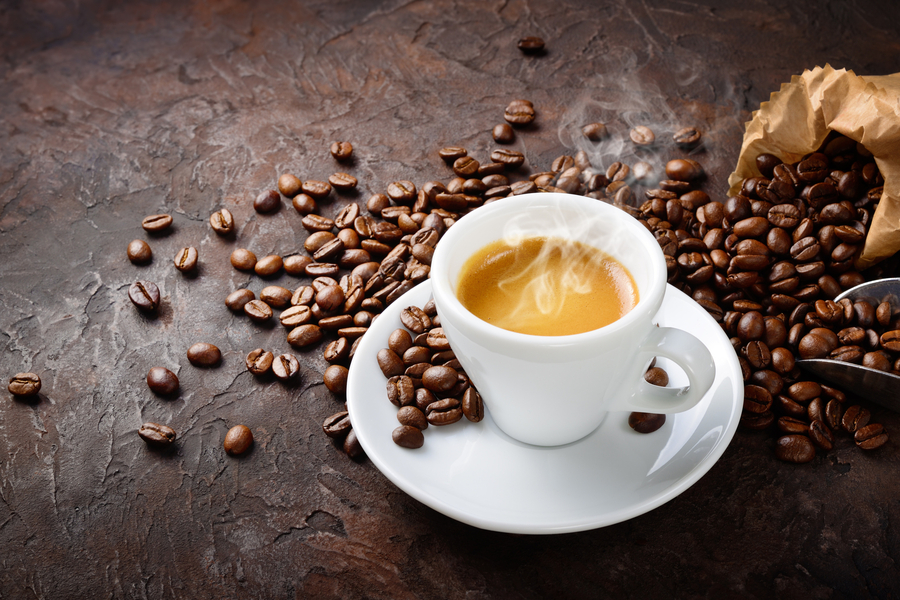 Tazzina di caffè con chicchi tostati.