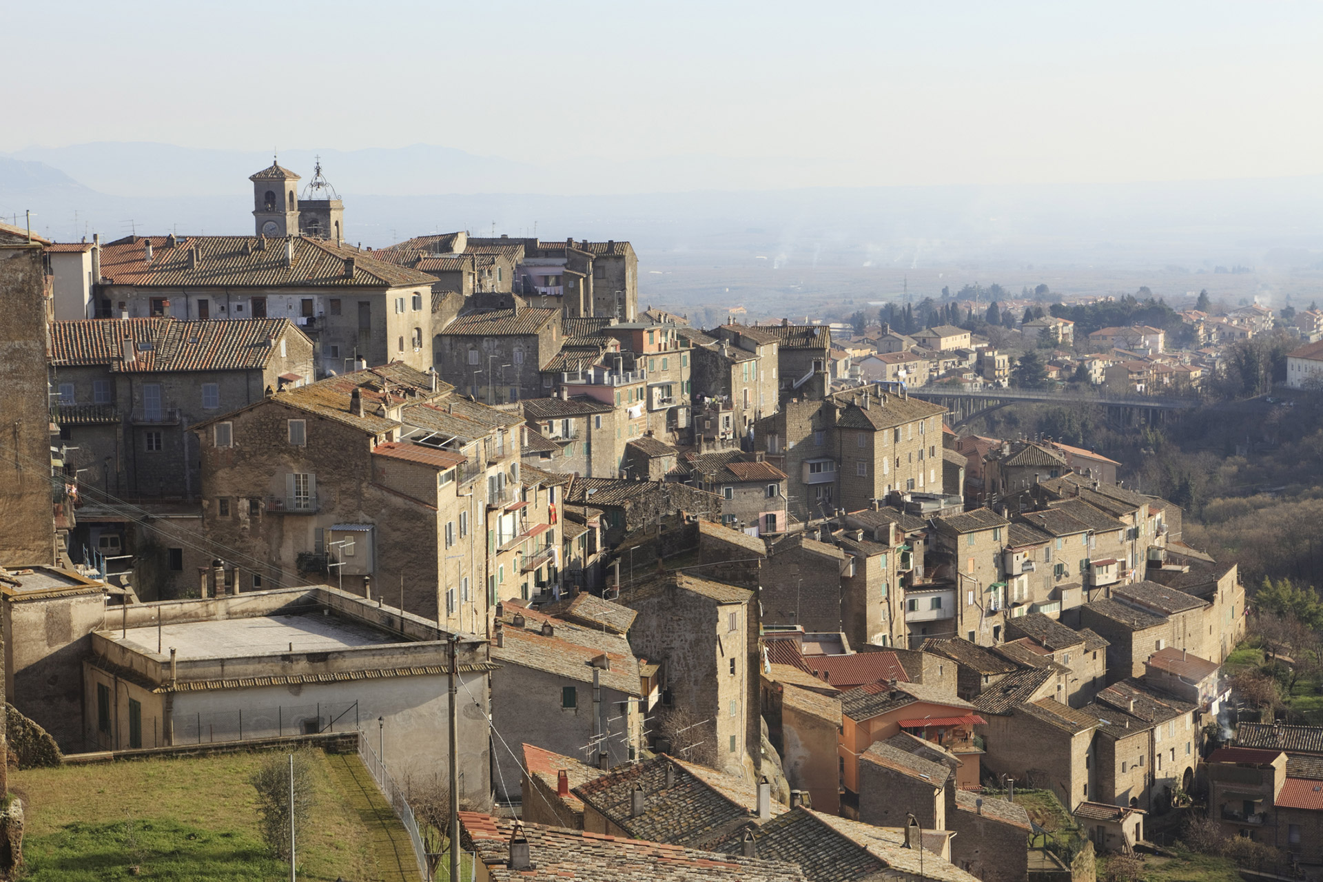 Vista panoramica del borgo di Caprarola con case in pietra e tetti rossi.