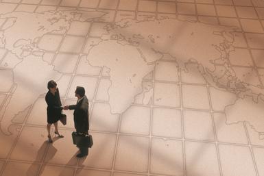 Due persone camminano in un aeroporto, viste dall’alto, sul pavimento con mappa stilizzata.