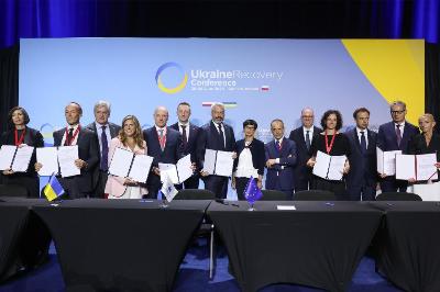 Delegati in posa con un documento firmato, bandiere ucraine ed europee