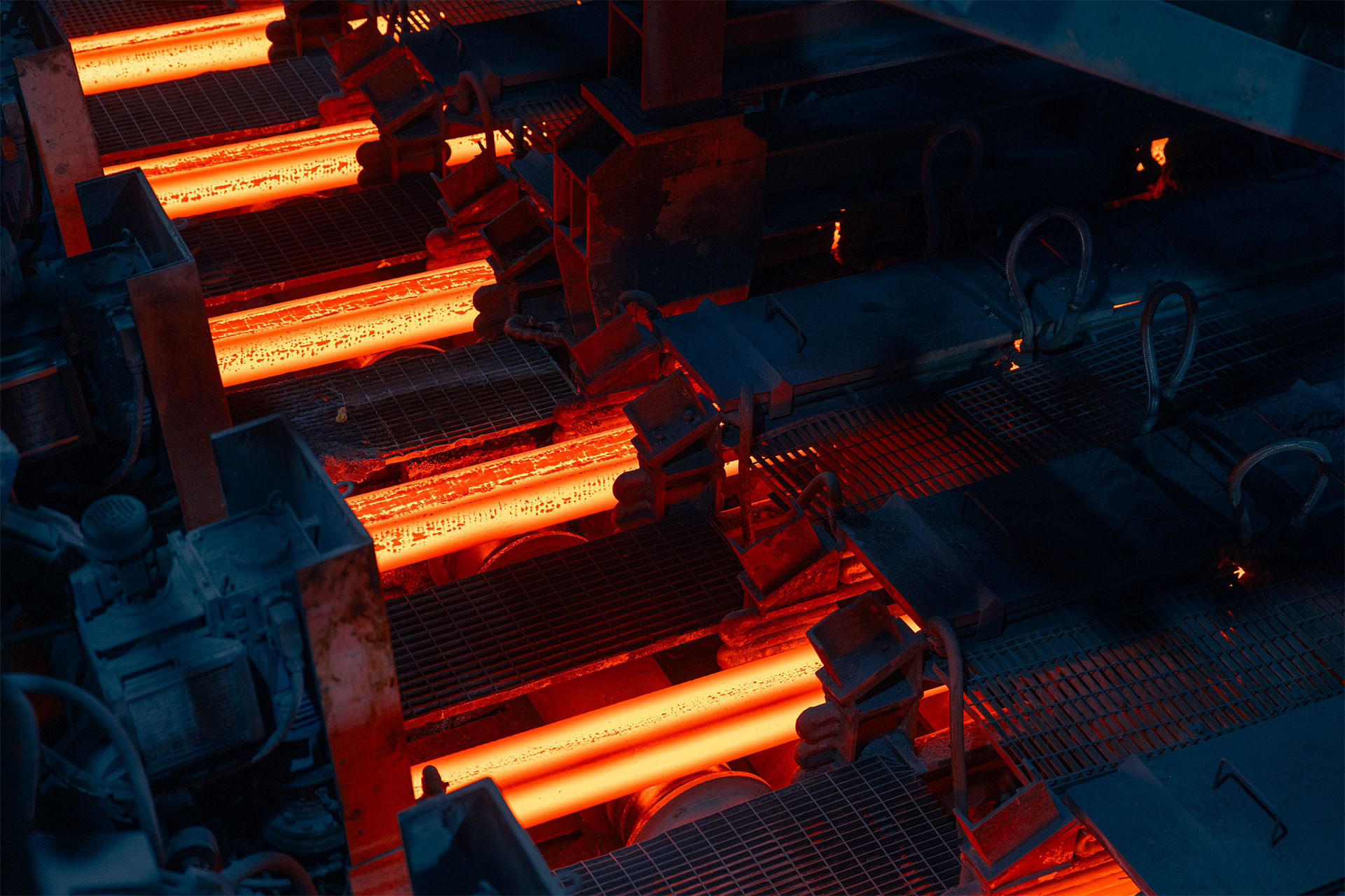 Barre di acciaio incandescenti in un impianto industriale di laminazione