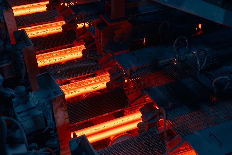 Barre di acciaio incandescenti in un impianto industriale di laminazione