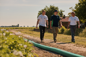 Tre uomini che camminano in una strada di campagna