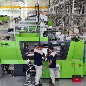 Operai controllano una macchina industriale in fabbrica.