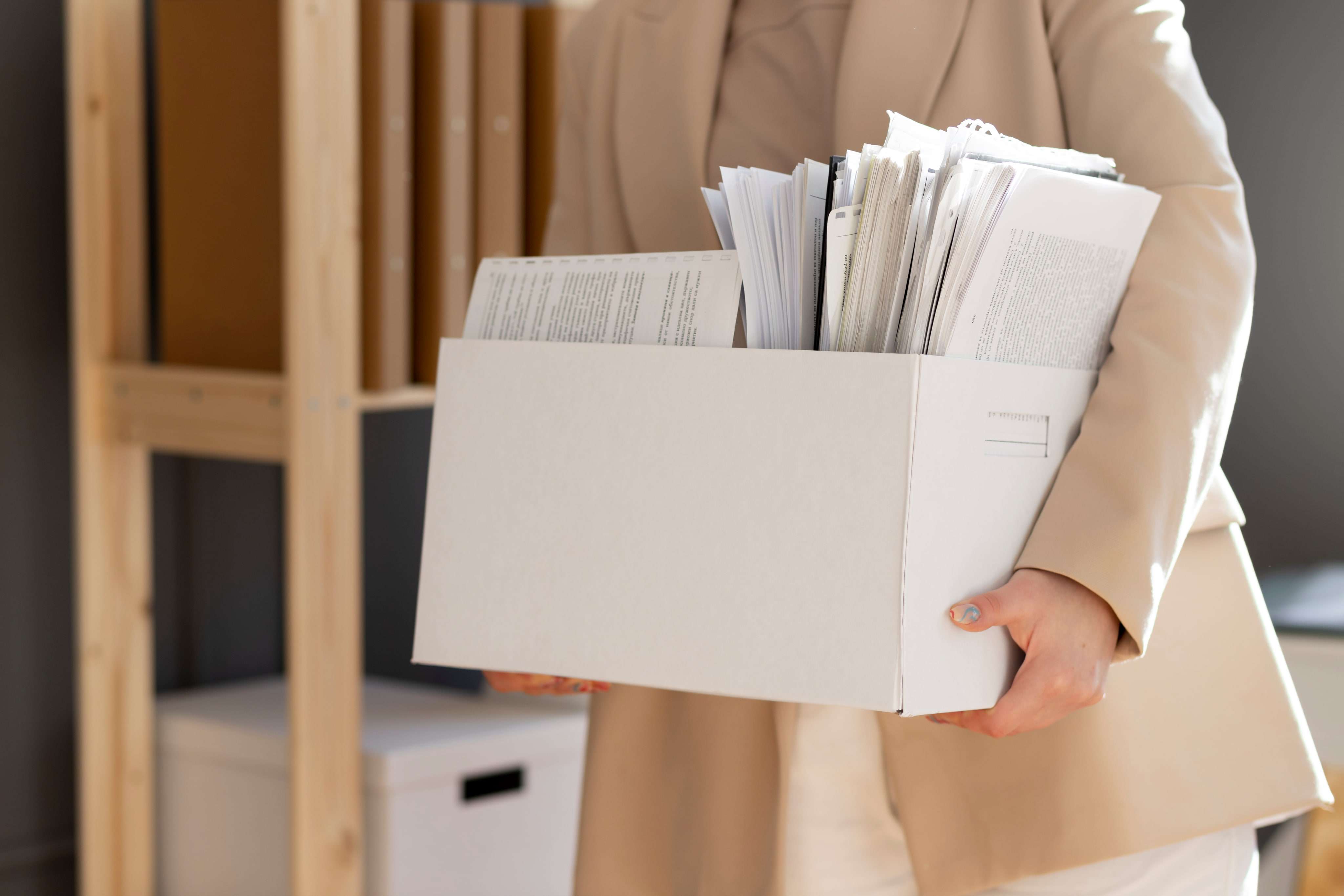 Una persona tiene in mano una pila di lettere e buste vicino a scatole di legno.