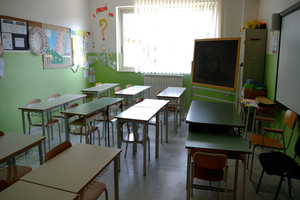 Aula vuota di una scuola media con banchi e lavagna.