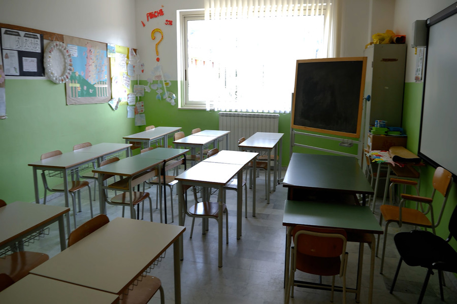 Aula vuota di una scuola media con banchi e lavagna.
