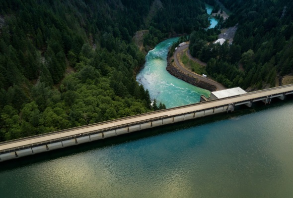 Autostrada sul fianco di una valle con un fiume di colore turchese.
