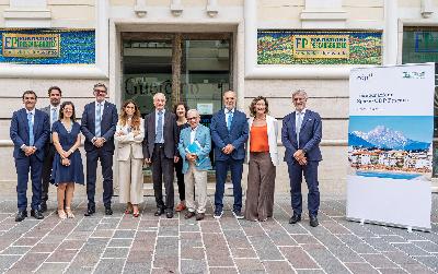 Gruppo di persone in posa davanti a un edificio, davanti a targhe e insegne di fondazione pescarabruzzo.