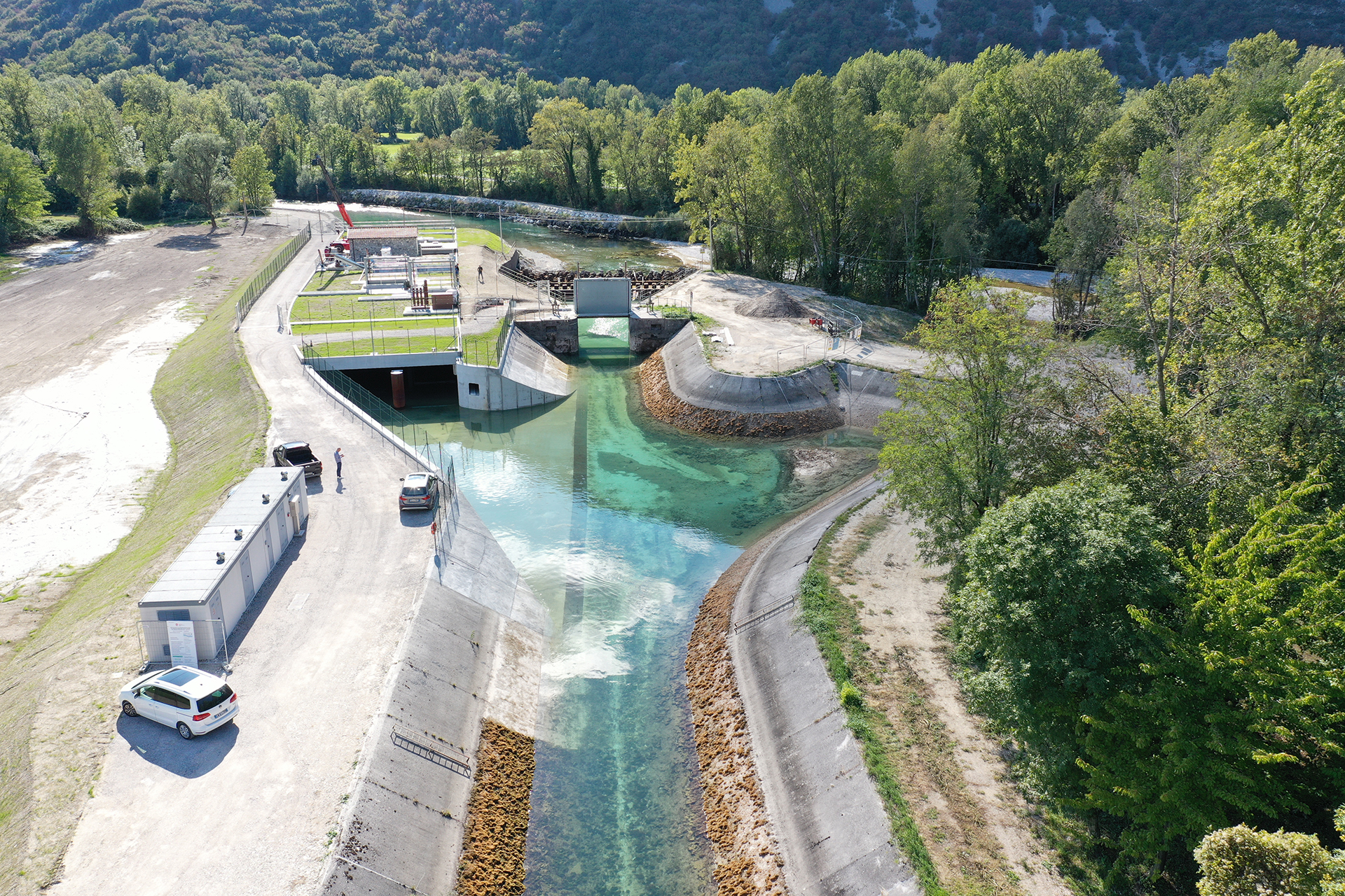 Impianto idroelettrico con canale e vasca di raccolta.