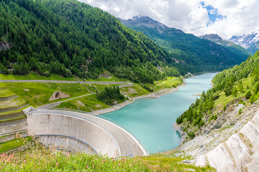 Diga e lago di montagna circondati da boschi.