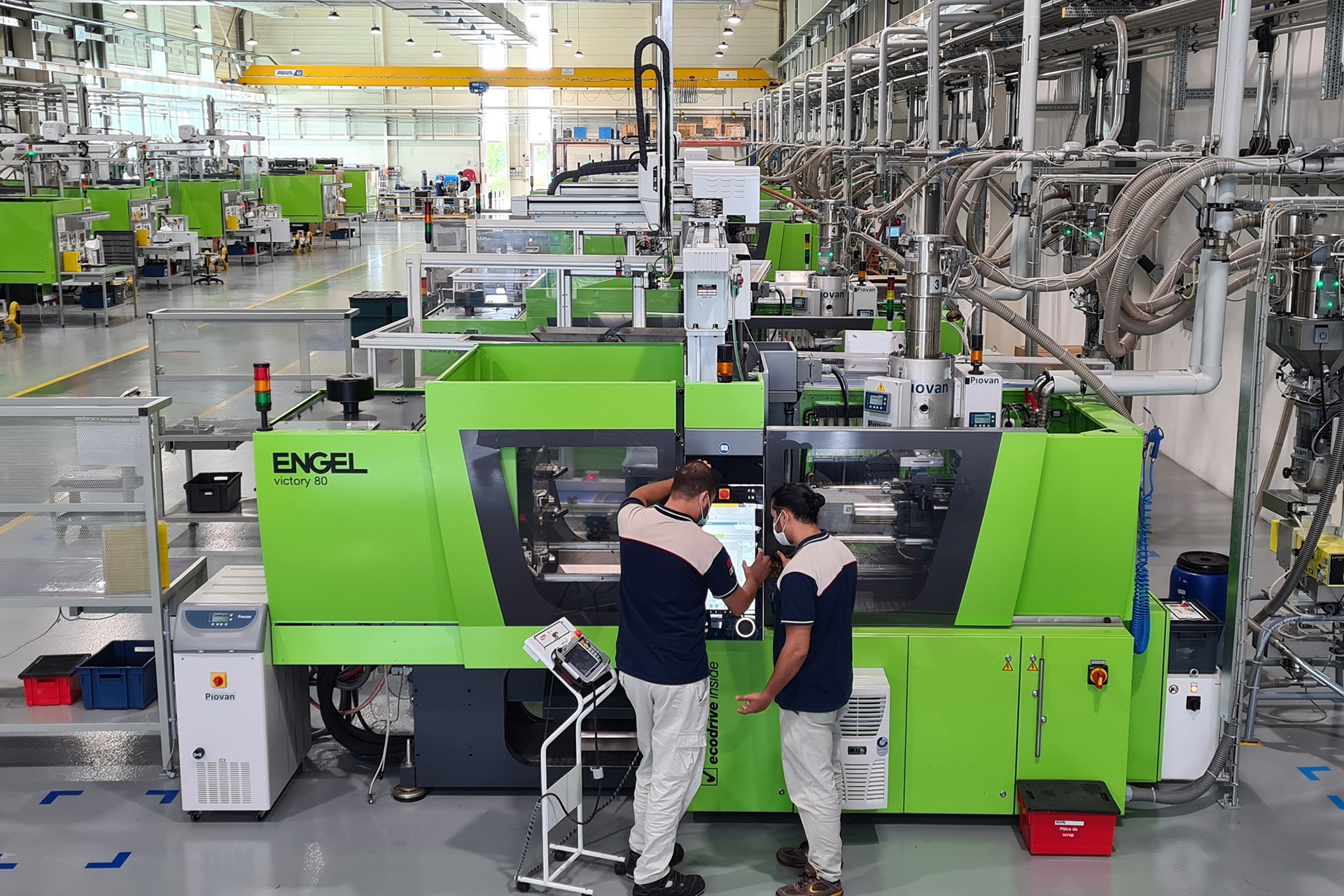 Operai controllano una macchina industriale in fabbrica.
