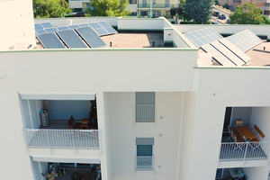 Facciata bianca di un palazzo residenziale con pannelli fotovoltaici