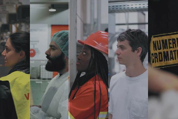Quattro persone in abiti da lavoro e dispositivi di sicurezza in un ambiente industriale.