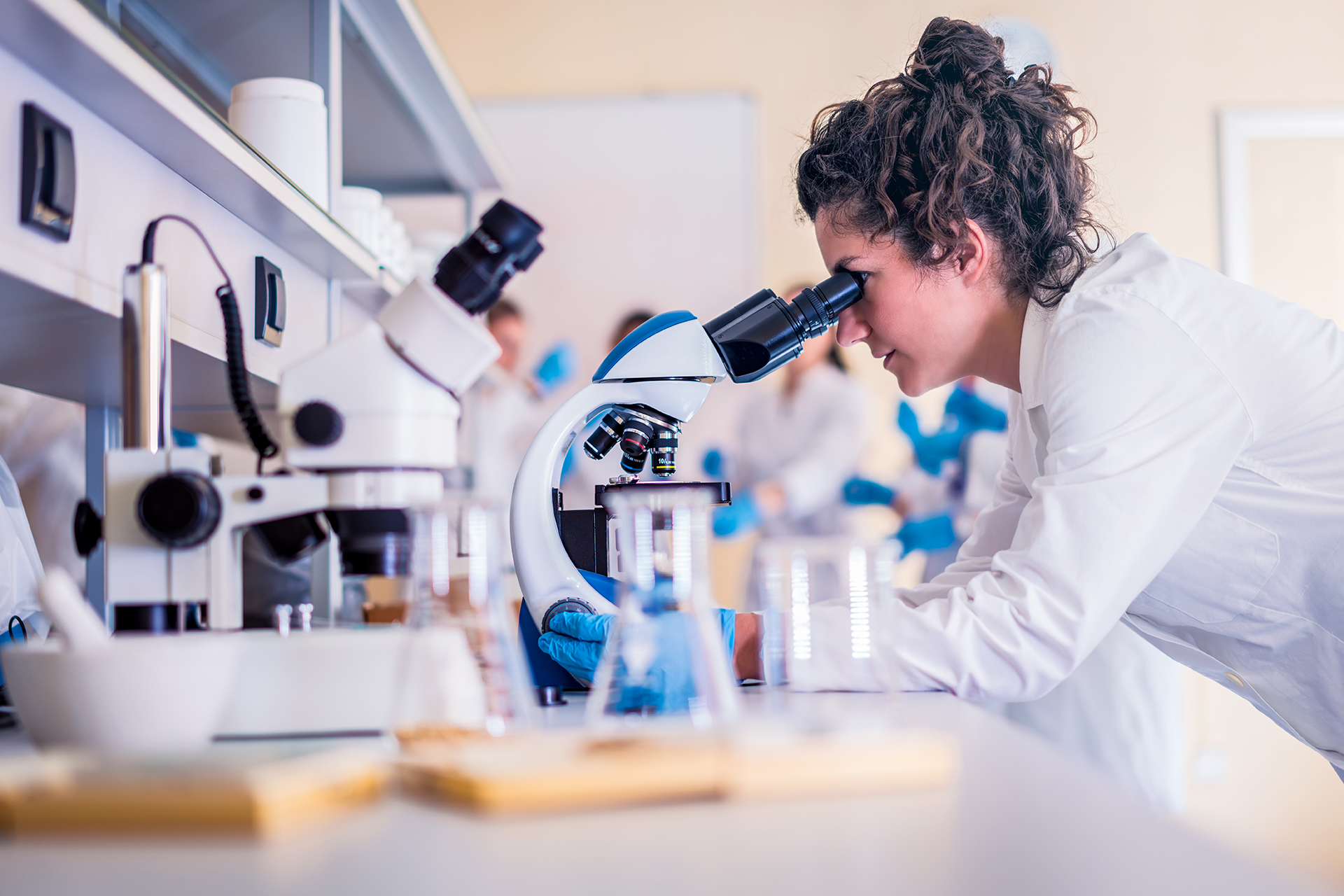 Ragazza che lavora in laboratorio e guarda dentro a un telescopio