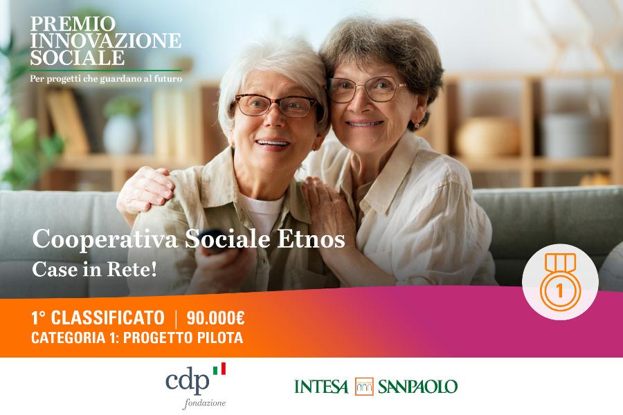 Due anziane sorridenti abbracciate in casa, con grafica del “Premio Innovazione Sociale” e indicazione di “1° classificato”.