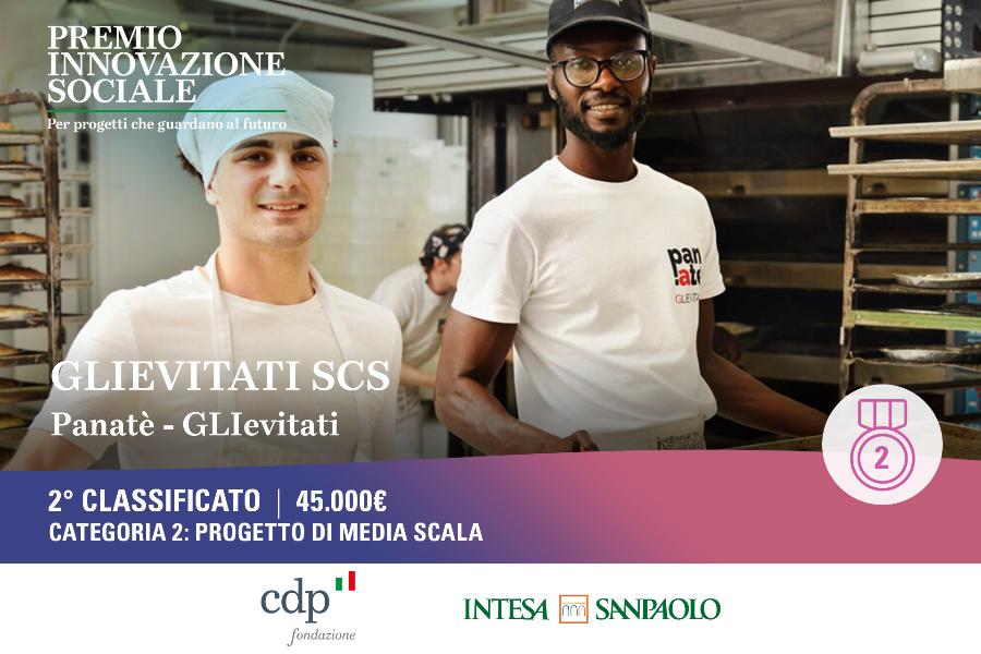 Due giovani sorridenti lavorano in una cucina industriale; sullo sfondo scaffali e una grafica del “Premio Innovazione Sociale” con “2° classificato”.